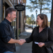 Two business owners shaking hands outside a downtown Prescott storefront