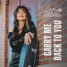 Lisa Mitts with long dark hair in black lace top leaning on red brick wall holding black guitar case for Carry Me Back To You cover