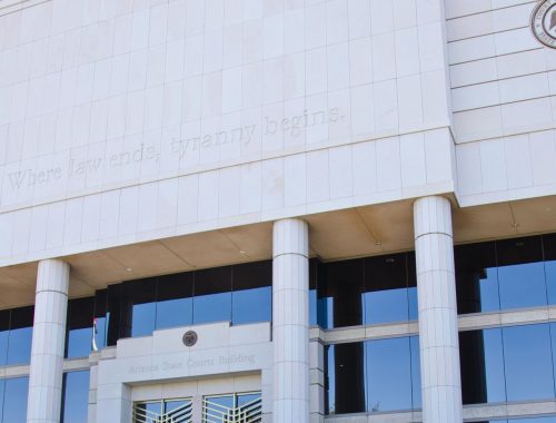 The Arizona State Courts Building in Phoenix, home of the Arizona Supreme Court, with the words "Where law ends, tyranny begins" carved above its entrance.