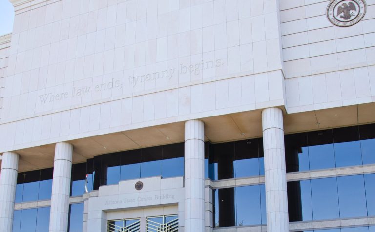 The Arizona State Courts Building in Phoenix, home of the Arizona Supreme Court, with the words "Where law ends, tyranny begins" carved above its entrance.