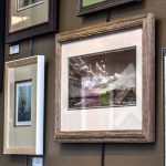 How to hang pictures: framed photographs and prints hung in a tidy group on a gallery wall at Framers Market & Gallery.