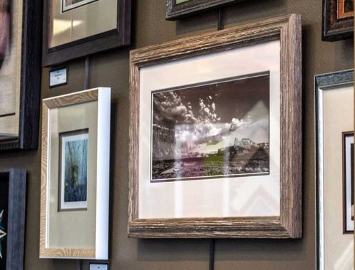 How to hang pictures: framed photographs and prints hung in a tidy group on a gallery wall at Framers Market & Gallery.