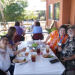 Older adults sit together at a patio table sharing a meal at the day center.
